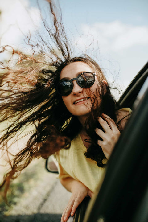 Woman leaning out of a car wearing Vilo Sunglasses